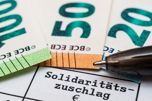 Schriftzug Solidaritätszuschlag und Geldscheine